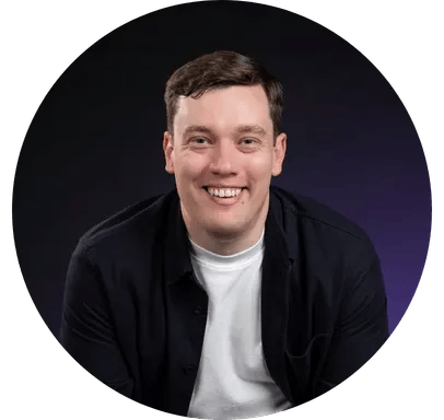 Man smiling at camera, wearing black jacket and white t-shirt, portrait against dark purple gradient circular background
